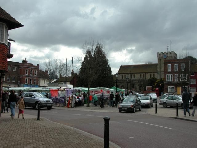 Petersfield Market Square with market stalls, historic buildings and St Peter's Church visible in the background
